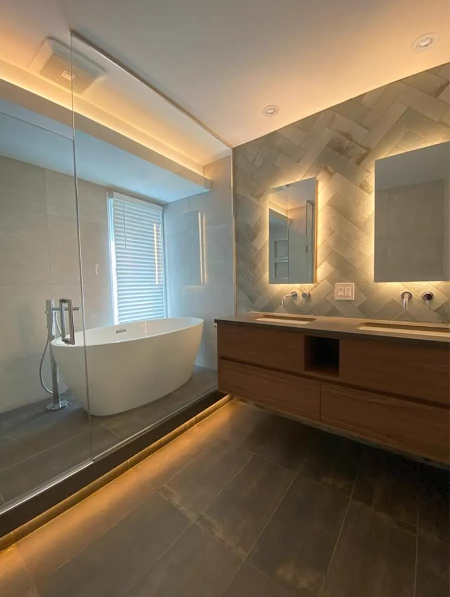 Salle de bain rénovée avec bain autoportant, douche vitrée et double vanité éclairée