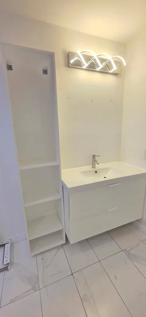 Vanité blanche avec lavabo et luminaire mural